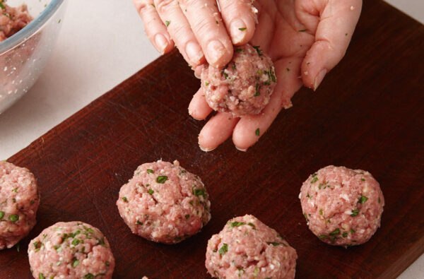 Use a cookie scooper or two spoons to make the meatballs and roll them in between your hands to make it smooth. Place on a baking sheet lined with parchment paper.
